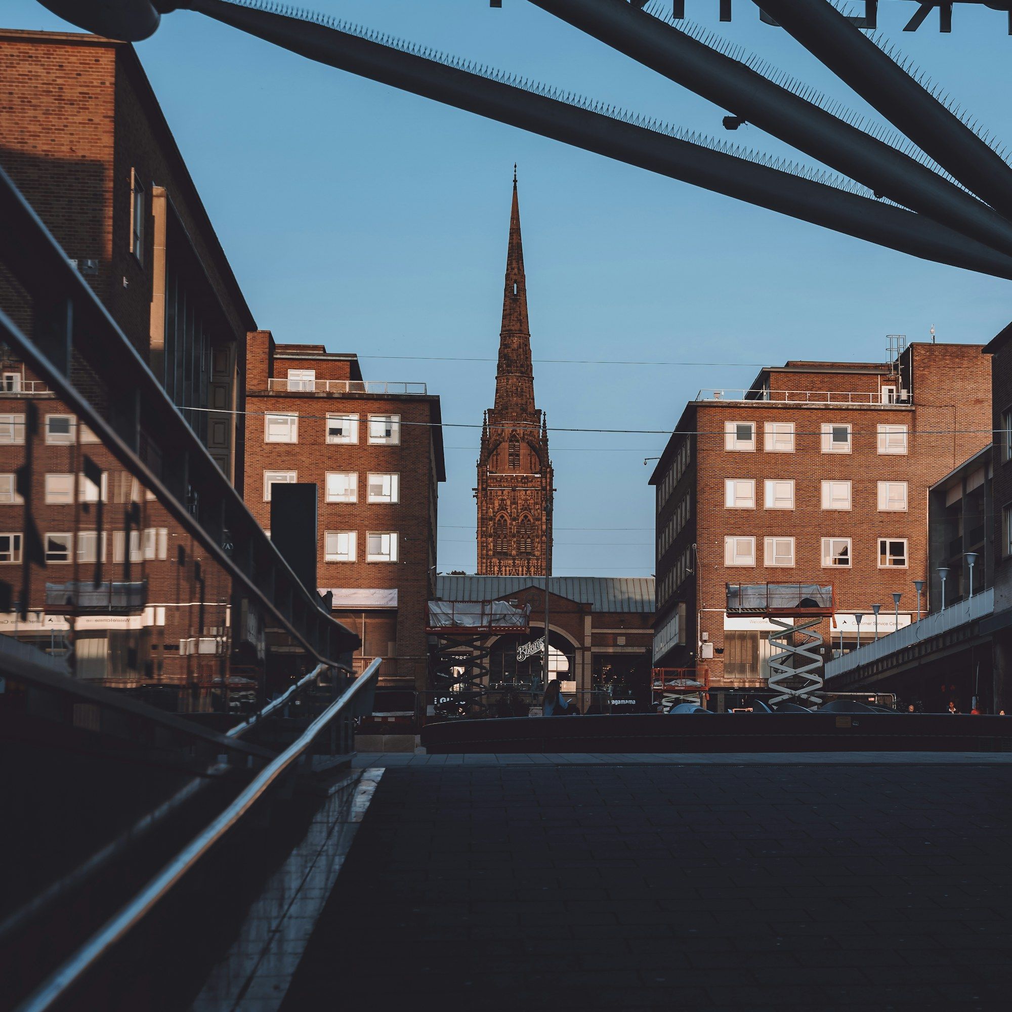 A church spire between buildings on Coventry’s High Street